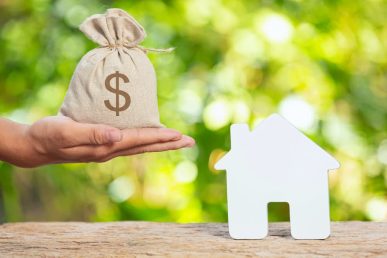 Ganancias patrimoniales por venta de vivienda representadas con casa y saco de dinero